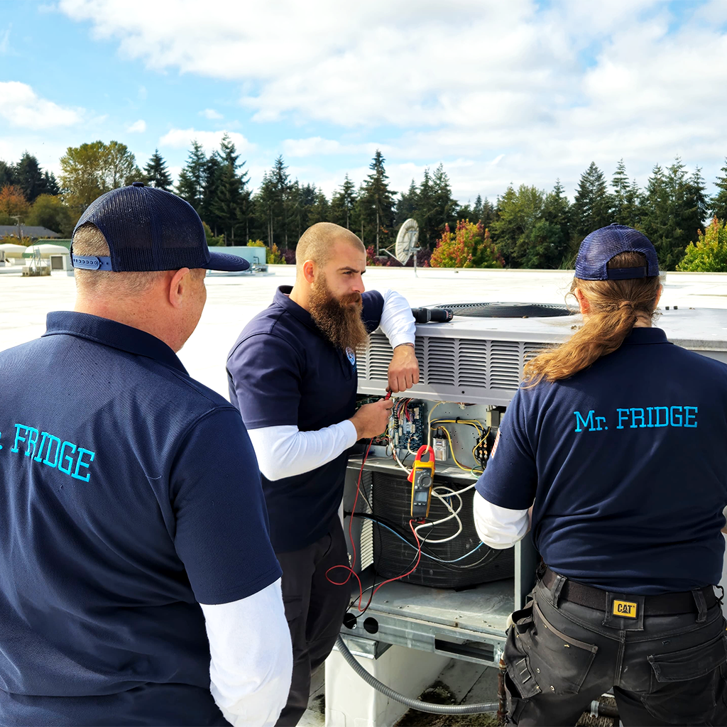 Three Mr. Fridge Austin technicians on a rooftop repairing a commercial refrigeration compressor for a walk-in cooler in Austin, TX.
