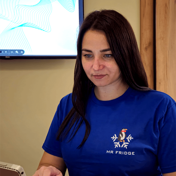 Christina in a Mr. Fridge shirt working at a desk